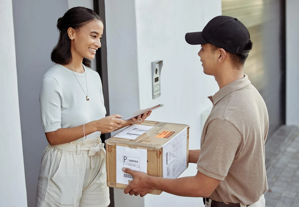 A woman receiving an online shopping delivery from a courier