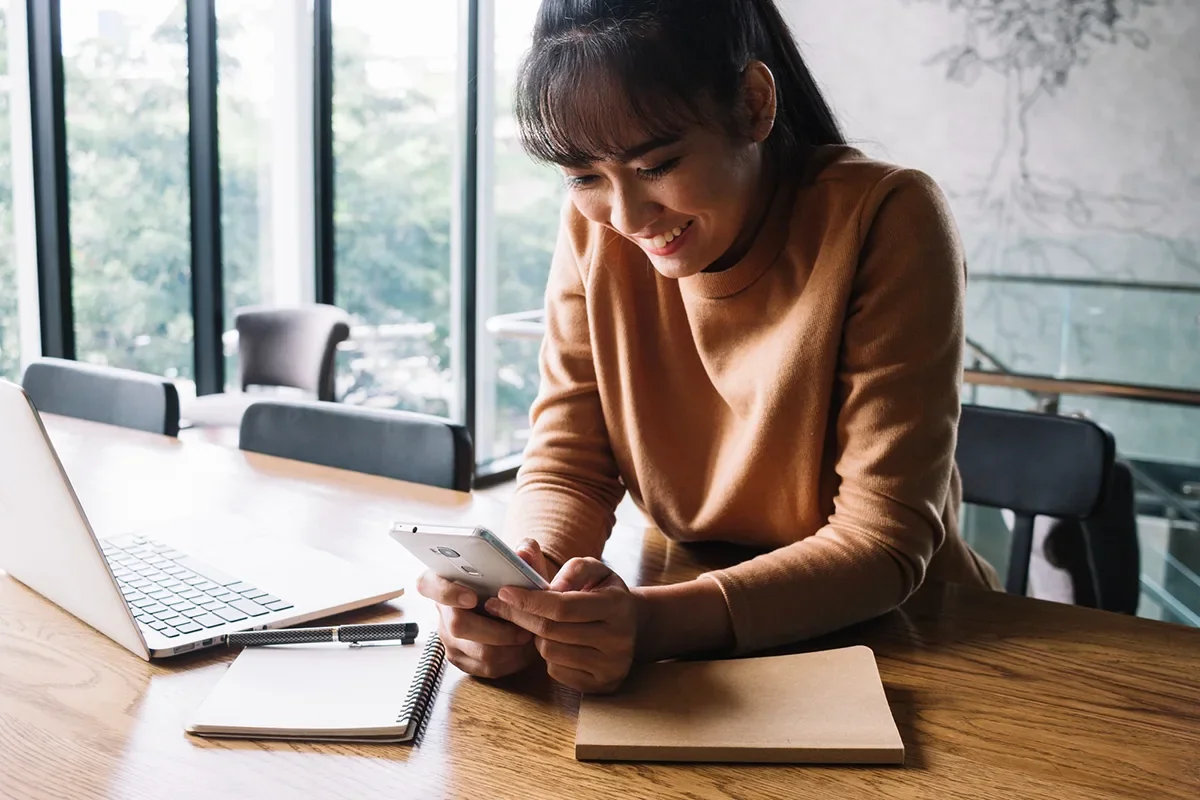 A woman checking a mobile-friendly email campaign design on a smartphone.