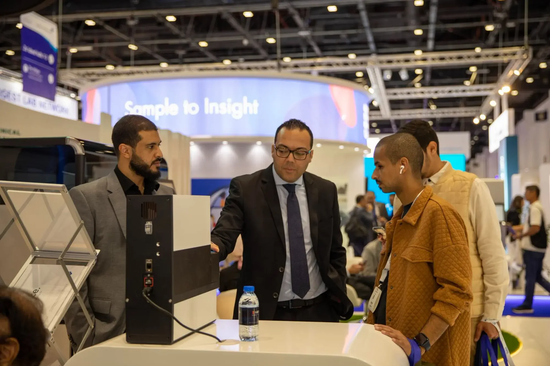 Business professionals interacting at a trade show booth during a live event