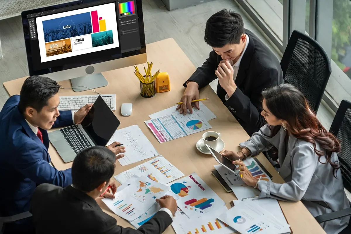 Marketing team reviewing analytics and design materials during a strategy meeting.