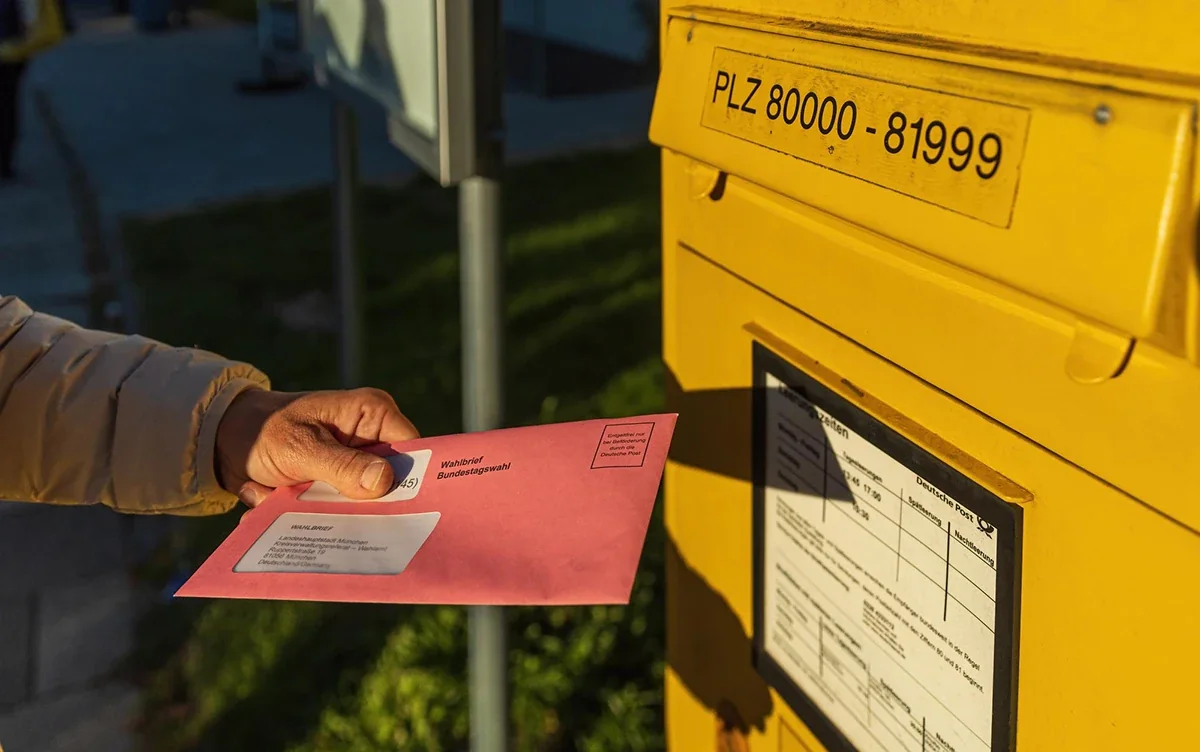 Close-up of a person mailing a branded envelope as part of a product launch marketing strategy