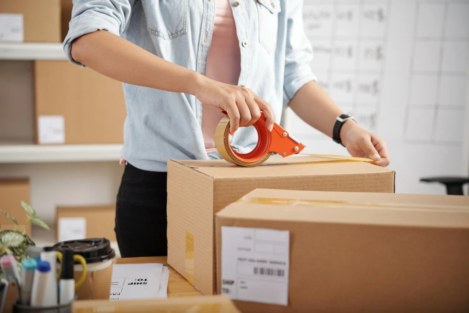 Sales support fulfillment team member packing and labeling a box for shipment