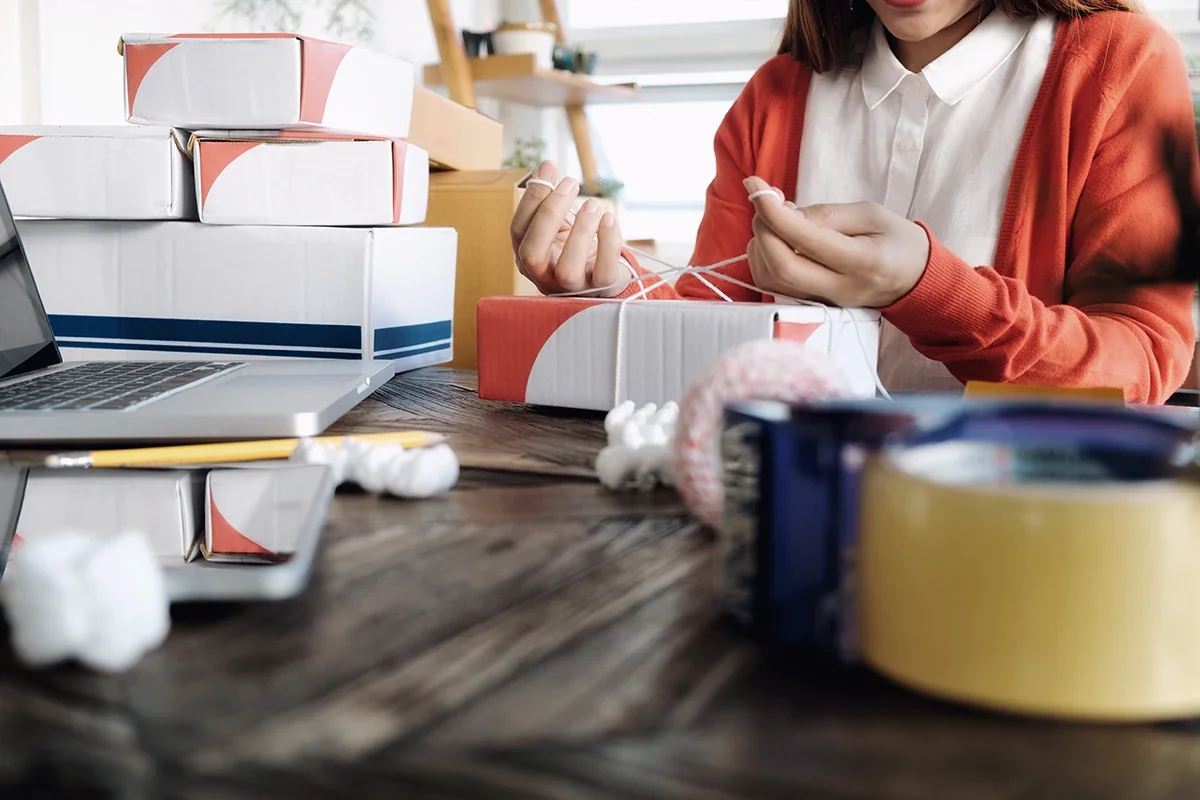 Kitting and assembly services in action, with hands assembling product kits using packaging materials and labeled containers