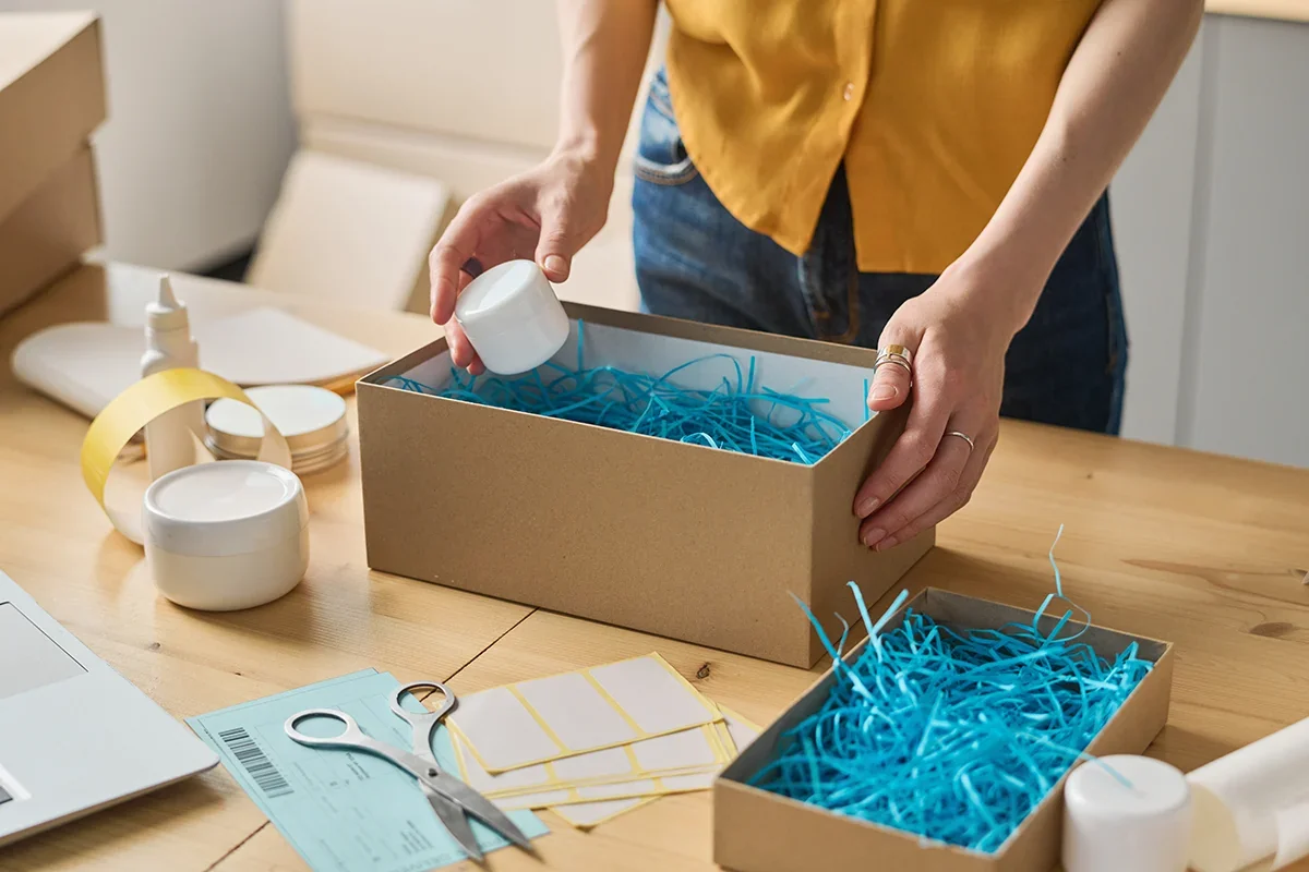 Kitting and assembly services with someone packing boxes by hand using string and packaging materials