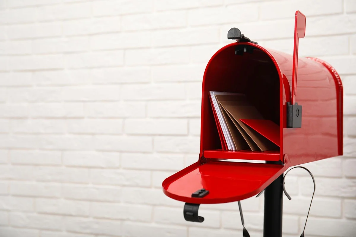 Red mailbox with postcards inside representing direct mail marketing and postcard campaigns for retailers